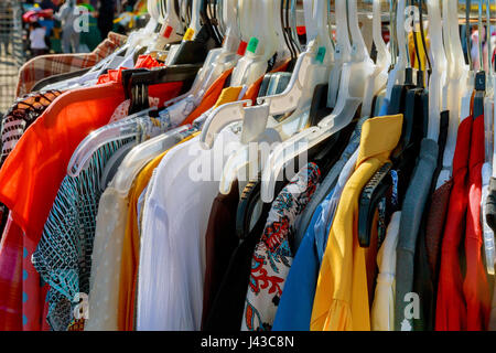 Modekleidung auf Kleiderbügeln auf der Messe Stockfoto