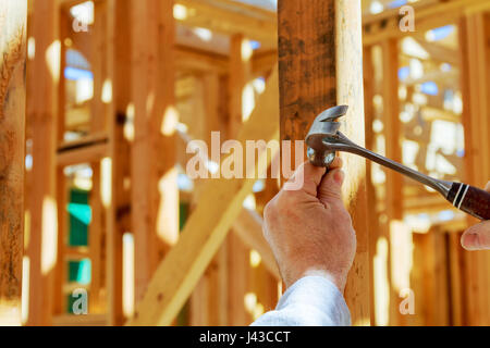 Baumeister Arbeitskraft Nagelung mit Hammer im Wandaufbau arbeitet Stockfoto