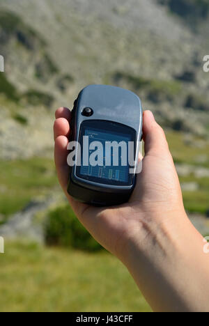 Mann, der einen GPS-Empfänger in der Hand hält. Handheld-GPS-Geräte sind überwiegend in der Freizeit-Industrie verwendet, für Spaziergänge und Wanderungen. Stockfoto