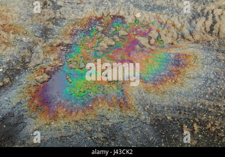 Puddled Wasser verschmutzt mit Kraftstoff verschütten. Gas-Spill in Regenbogenfarben Stockfoto