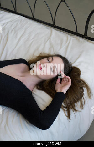 Schöne junge Frau schlafen im Bett Stockfoto