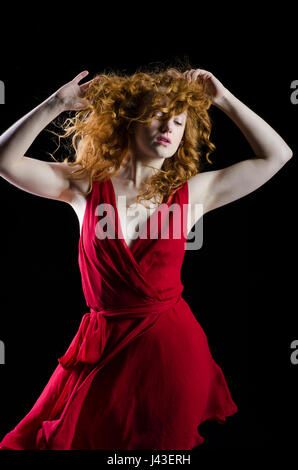 Schöne rothaarige Frau Hände berühren wallendes Haar Stockfoto