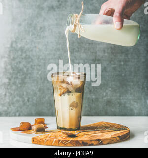 Mannes hand Gießen Milch Iced Latte Sommer Kaffee cocktail Stockfoto