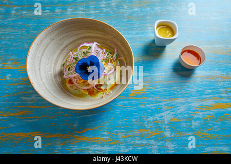 Fisch Ceviche Latin Preuvian Rezept auf Schüssel mit Stiefmütterchen Blume Stockfoto