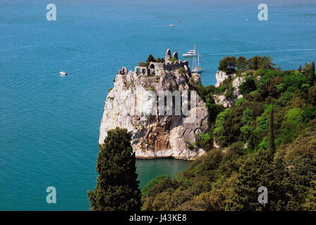 Die Reste der alten Burg von Duino bei Triest. Die ersten befestigte Kern des Schlosses Duino erhebt sich im 11. Jahrhundert auf einem Felsvorsprung über dem Meer und vor dem neuen Schloss. Ruinen sind durch einen Weg und eine Zugbrücke erreichbar. Die alte Dame Schloss knüpft an die Legende der weißen Frau. Stockfoto