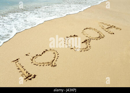 Weiche Welle des blauen Ozeans am Sandstrand mit Worten auf "Sand ich liebe Goa" Stockfoto