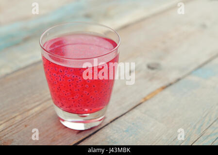 Basilikumsamen trinken mit Granatapfel-Saft im Glas auf hölzernen Hintergrund Stockfoto