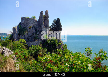 Die Reste der alten Burg von Duino bei Triest. Die ersten befestigte Kern des Schlosses Duino erhebt sich im 11. Jahrhundert auf einem Felsvorsprung über dem Meer und vor dem neuen Schloss. Ruinen sind durch einen Weg und eine Zugbrücke erreichbar. Die alte Dame Schloss knüpft an die Legende der weißen Frau. Stockfoto