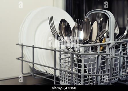 Sauberes Besteck und Teller nach dem Waschen im Geschirrspüler Maschine Stockfoto