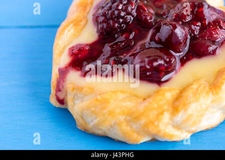 Vanille-Sahne und Obst Berry Blätterteig Dessert auf blauem Hintergrund Stockfoto