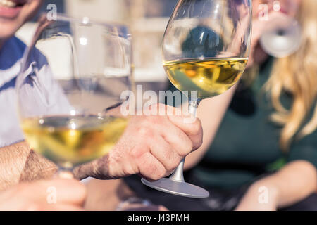 Freunde jubeln mit Weingläsern im Restaurant unter freiem Himmel Stockfoto