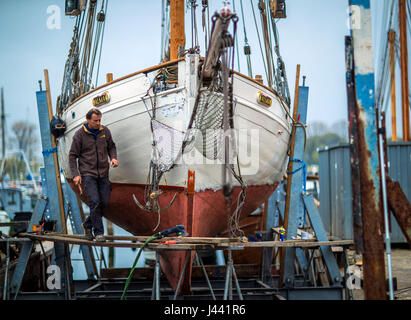 Insel Poel, Deutschland. 6. Mai 2017. Schweizer Gaspard Barraud aus Montreux ist Woking mit seinen Lachs Kutter "Omi Alma" (lit. Oma Alma) von 1928 an der Wharf auf Insel Poel, Deutschland, 6. Mai 2017. Das 89 Jahre alten Holzboot aus Basel ist eine neue Abdichtung und Unterwasser Farbe bekommen. Nur Holzboot Kai auf der Insel Poel verfügt derzeit über volle Auftragsbücher und Repars traditionelle hölzerne Fischerboote neben Sportboote. Foto: Jens Büttner/Dpa-Zentralbild/ZB/Dpa/Alamy Live News Stockfoto