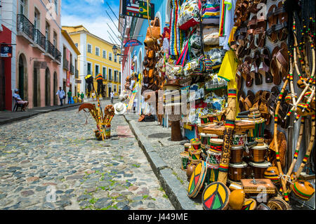 SALVADOR, Brasilien - 9. März 2017: Souvenirläden verkaufende Taschen und lokales Kunsthandwerk Linie der traditionellen kopfsteingepflasterten Straßen des historischen Pelourinho. Stockfoto