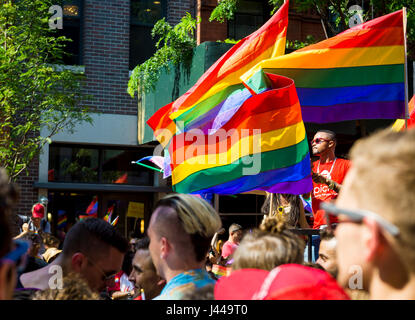 NEW YORK CITY - 28. Juni 2015: Unterstützer Welle Regenbogen Fahnen am Rande der jährlichen Pride Parade als es durchquert Greenwich Village. Stockfoto