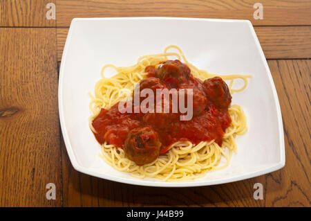 Fleischbällchen In Tomatensauce auf Spaghetti auf einem weißen Teller Stockfoto