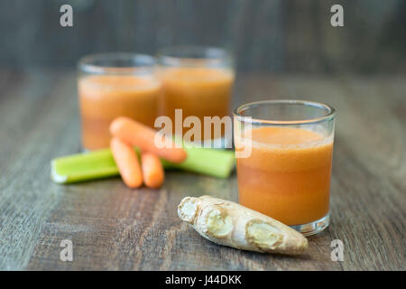 Frischer Karottensaft mit Ingwer-Wurzel und Sellerie Stockfoto