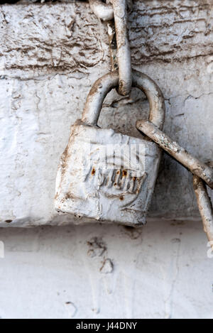 Alte hölzerne Tor auf eine rostige Vorhängeschloss mit Farbe über es in Dschibuti East Africa geschlossen Stockfoto