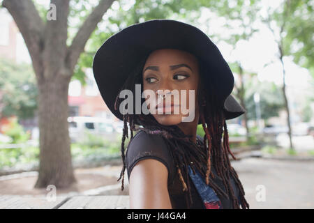 Eine junge Frau mit einem schwarzen Hut. Stockfoto