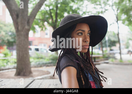 Eine junge Frau mit einem schwarzen Hut. Stockfoto