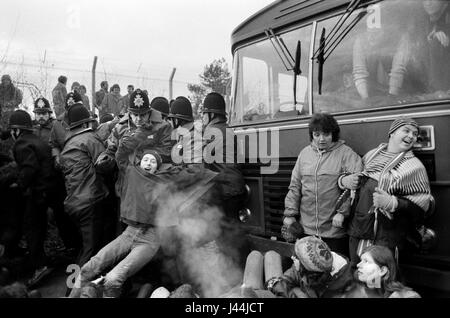 Greenham Common Womens Peace Bewegung. Frauen halten einen Bus an, während Arbeiter den Militärstützpunkt betreten. Die Polizei nimmt Verhaftungen vor. Dezember 1982 80er Jahre UK HOMER SYKES Stockfoto