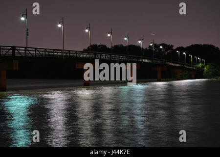 Leuchten die Spottdrossel Fußgängerbrücke in der Nacht am nördlichen Ende des White Rock Lake in Dallas, Texas Stockfoto