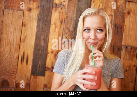 Glückliche gesunde junge Frau trinken frisch gepresst Saft in einem café Stockfoto