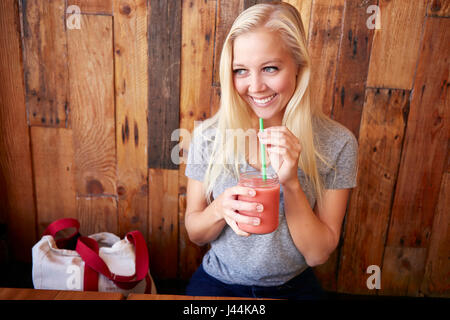 Glückliche gesunde junge Frau trinken frisch gepresst Saft in einem café Stockfoto