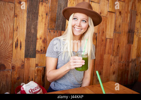 Glückliche gesunde junge Frau trinken frisch gepresst Saft in einem café Stockfoto