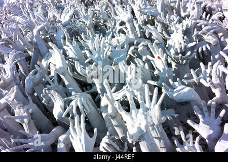 Ausgestreckten Hände die hemmungslose Lust am Wat Rong Khun, auch bekannt als der weiße Tempel in Chiang Rai. Stockfoto