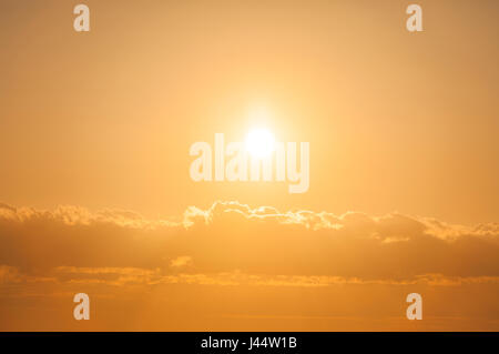 Sonne aus klarem Himmel über den Wolken bei Sonnenuntergang am Abend. Stockfoto