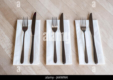 Besteck auf einem Tisch in einem Restaurant Messer Gabeln Servietten Servietten sauberen unbenutzten Utensilien Stockfoto