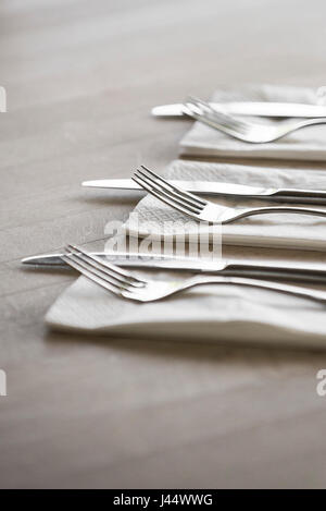 Besteck auf einem Tisch in einem Restaurant Messer Gabeln Servietten Servietten sauberen unbenutzten Utensilien Stockfoto