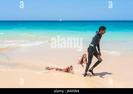 Kap VERDE-SAL junge im Neoprenanzug am Ponta Preta Strand in der Nähe von Draging ein Fang von Fischen in einer Zeile hinter Santa Maria Sal Insel Kapverden Afrika Stockfoto