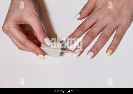 Hautnah auf den Händen der Frau Nagellack auftragen. Soft-Fokus Stockfoto