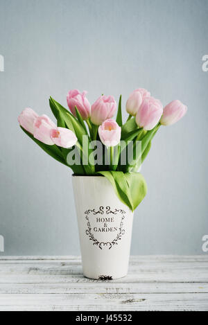 Bouquet von rosa Tulpen in Vase auf blauem Hintergrund Stockfoto