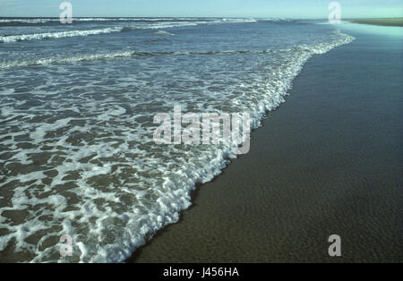 Sanft brechenden Wellen an einem Sandstrand im Vereinigten Königreich Stockfoto