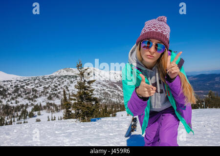 Erfolgreiche junge Mädchen Snowboarden in den Bergen Sheregesh. Snowboarder ruht.  Stilvolle kaukasischen Snowboarder. Snowboarder am Gipfel des Berges Stockfoto