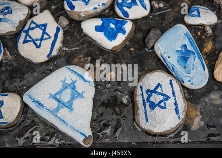 Handgemalte Steinen mit dem Davidstern gemalt durch Besucher am Fuße des Warschauer Ghetto Helden Denkmal links. Stockfoto