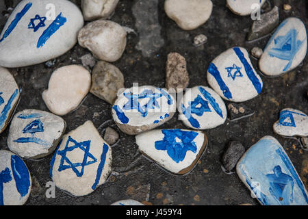 Handgemalte Steinen mit dem Davidstern gemalt durch Besucher am Fuße des Warschauer Ghetto Helden Denkmal links. Stockfoto