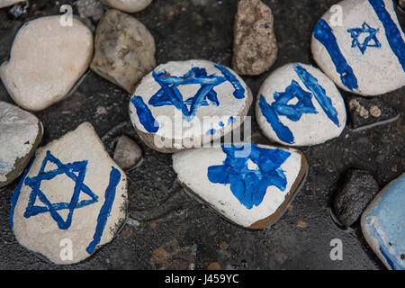 Handgemalte Steinen mit dem Davidstern gemalt durch Besucher am Fuße des Warschauer Ghetto Helden Denkmal links. Stockfoto