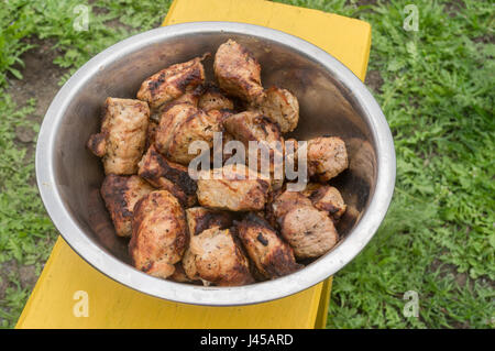 Stücke von leckeren Schweinefleisch gebraten auf einem Grill warten darauf, in einer Metallschale gegessen werden Stockfoto