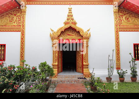 Halle auf der rechten Seite des Gebäudes mit weiß getünchten Mauer vergoldet Holz Schnitzereien-rote Lacquerware-Lotus Hauptstadt Säulen Kuti wiederhergestellt. Wat Chum Khong- Stockfoto