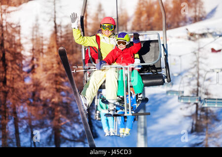 Glücklich Skifahrer am Sessellift heben und winken Hände Stockfoto