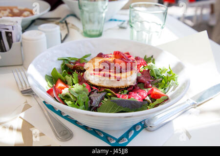 Ziegenkäse Salat mit grünen Blättern und Beeren auf einem Tisch Stockfoto