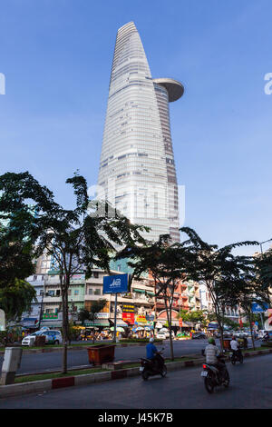 HO CHI MINH CITY, VIETNAM - Februar 07: Menschen fahren mit ihren Motorrädern auf der Straße mit Bitexco Financial Tower auf Hintergrund am Februar 07, Stockfoto