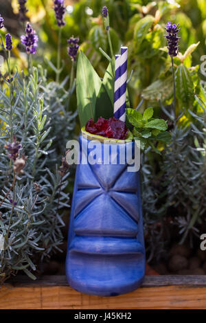 Tropische Cocktails serviert im Tiki-Stil Glas im grünen Stockfoto