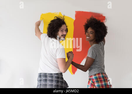 glückliche junge multiethnischen paar Malerei Innenwand des neuen Hauses Stockfoto