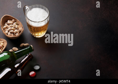 Lager-Bier und Snacks am Steintisch. Verschiedenen Nüssen. Mit Textfreiraum Stockfoto