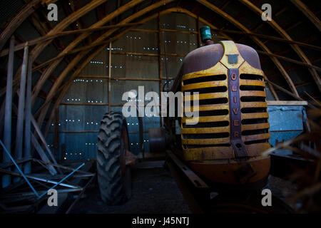 Eine alte Oliver Traktor wartet in der Scheune. Stockfoto