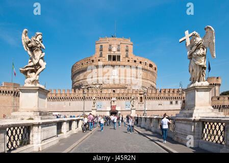 Castel Sant'Angelo mit den Touristen zu Fuß über die Fußgängerbrücke St. Angelo oder Ponte Sant'Angelo über den Fluss Tiber an einem sonnigen Tag. Stockfoto